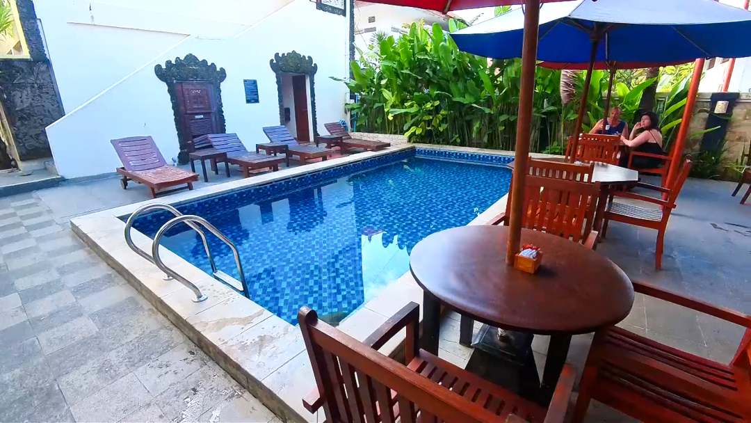 pool area at Sari Villa Sanur Bali with sun lounges and table and chairs